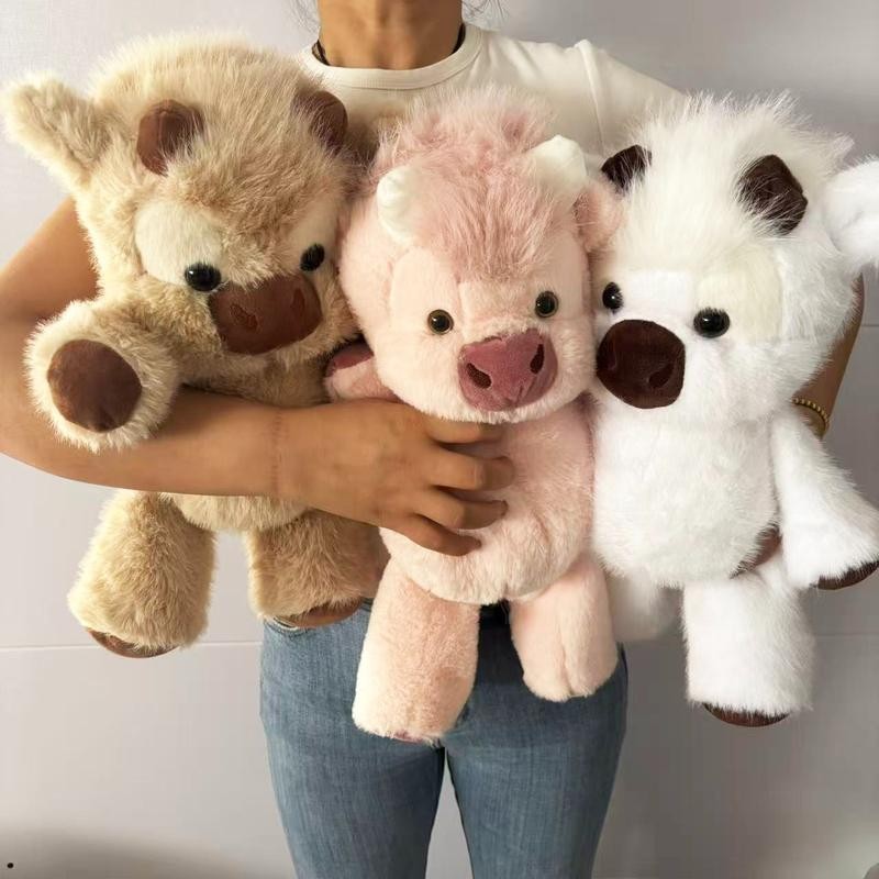 Clover the Highland Cow plush held as a gift, showing true oversized cuddle size