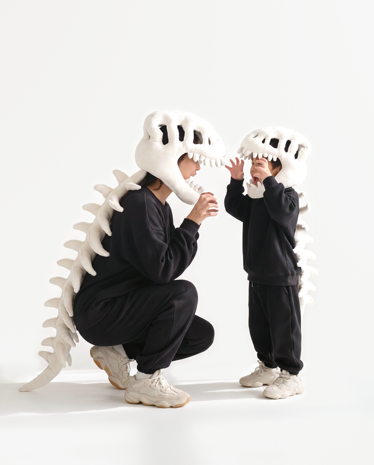 Bone Dinosaur Skeleton Costume, two people in matching costumes crouching with a child