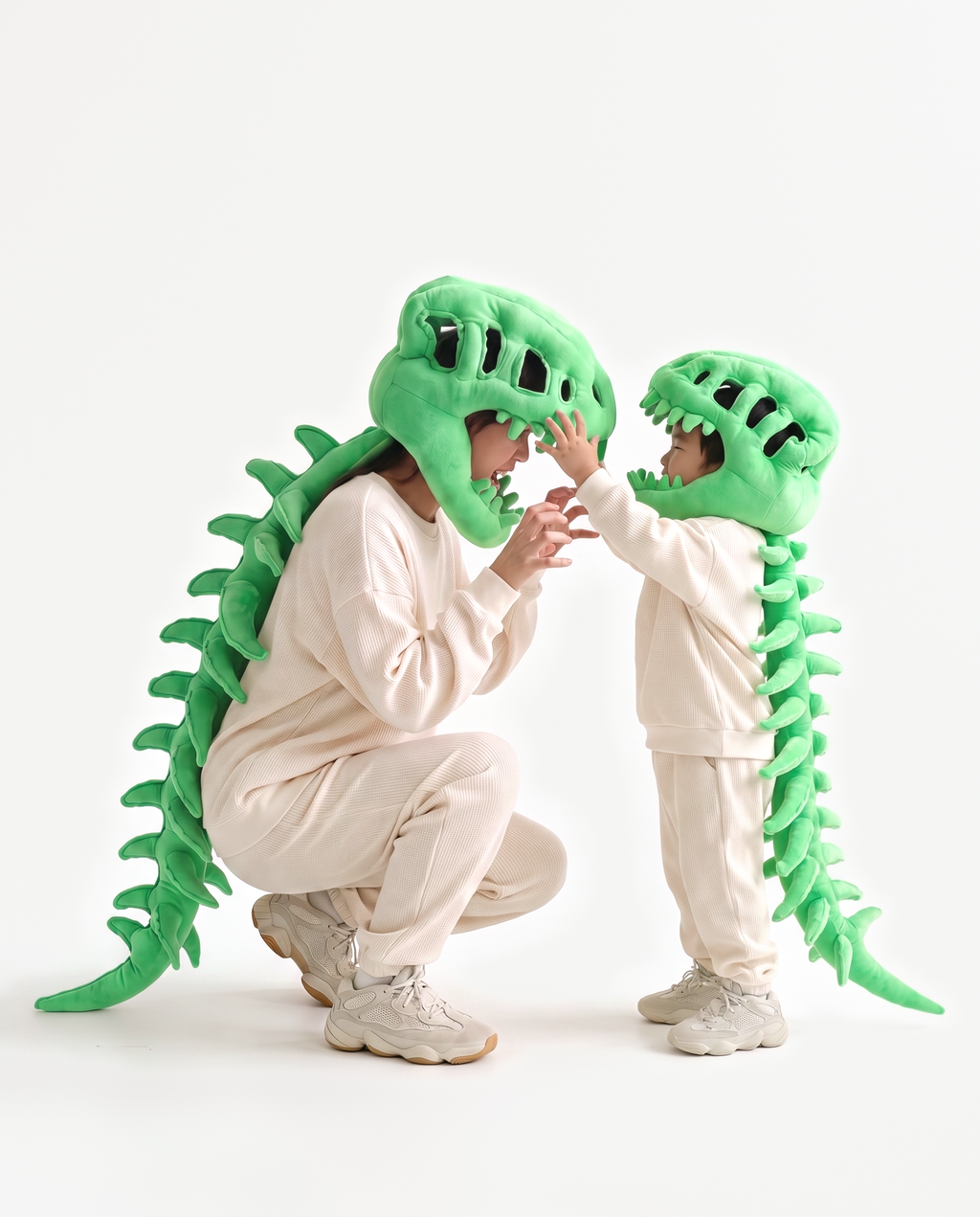 Green Dinosaur Skeleton Costume, two people in matching costumes crouching with a child
