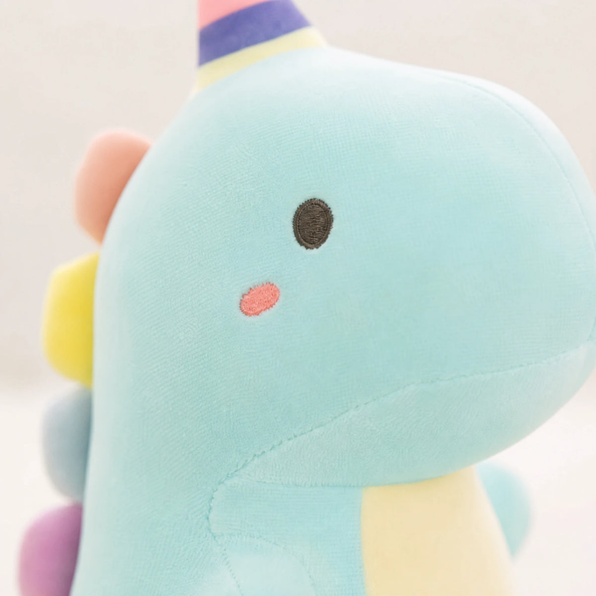 Dinosaur Plush Toy with Rainbow Party Hat and Pastel Colors - Détail matière