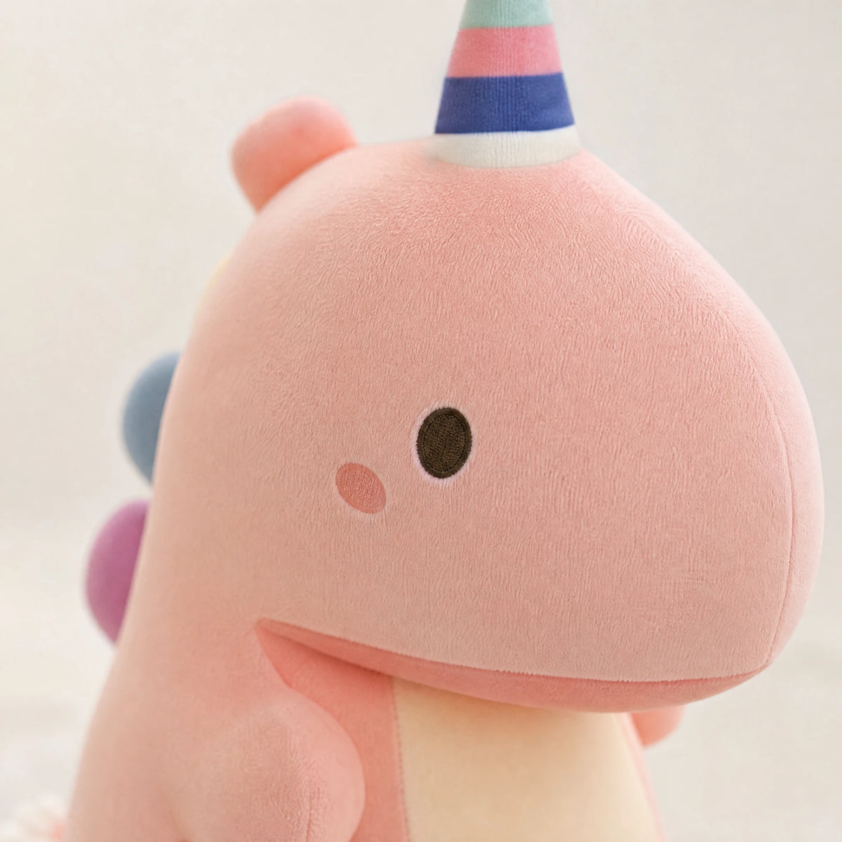 Dinosaur Plush with Rainbow Hat and Pastel Colors - Détail matière