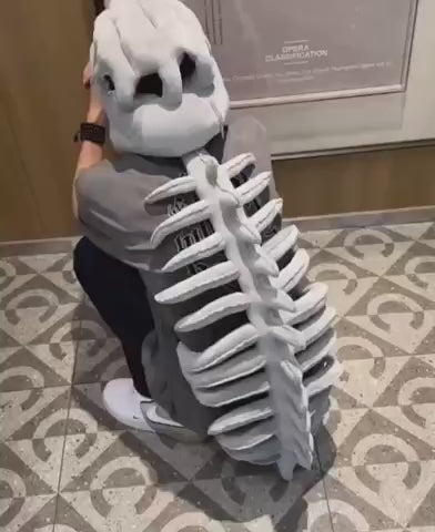 Adult wearing the Grey Dinosaur Skeleton Costume over a t-shirt, skull hood and spine